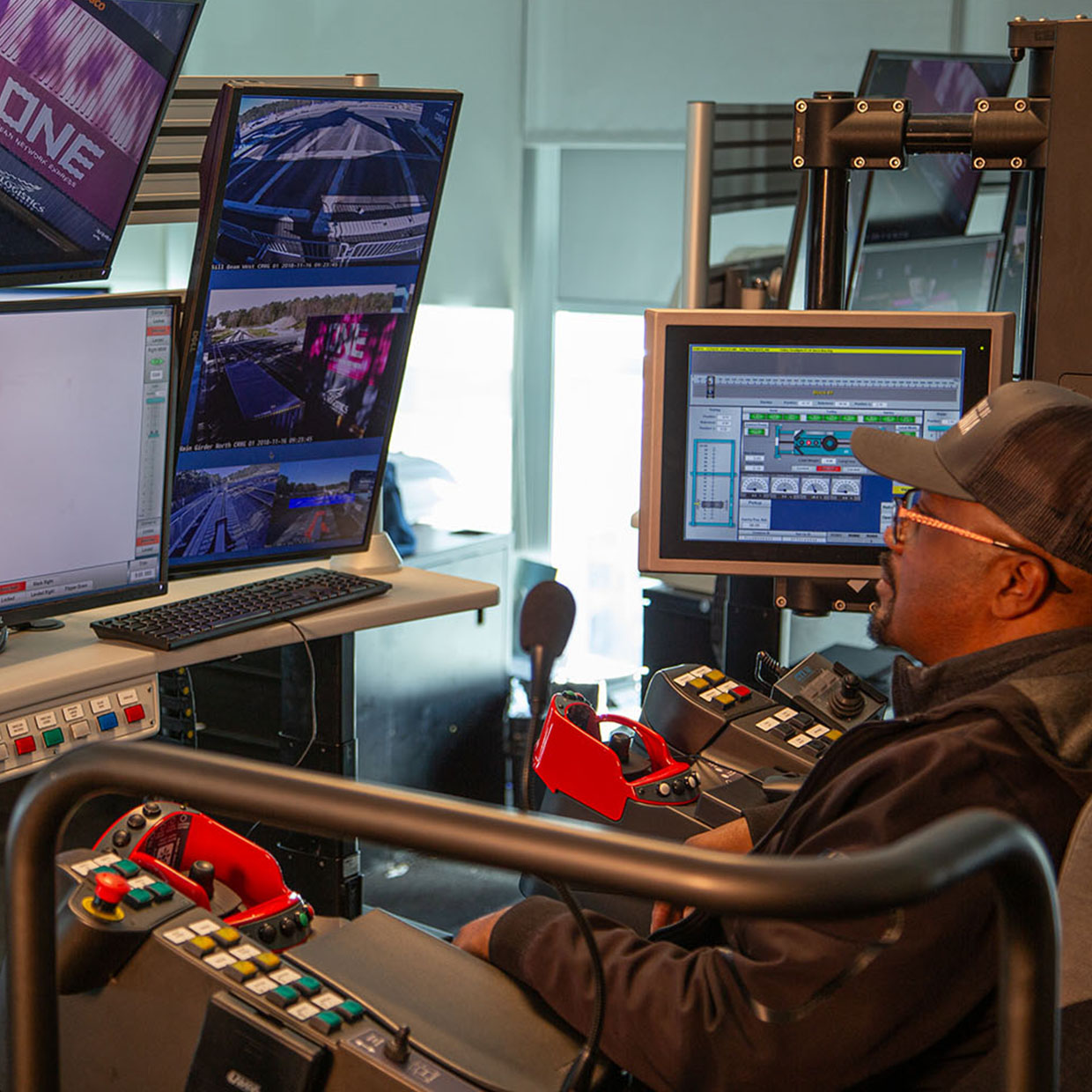 A crane control room setup with multiple monitors in use