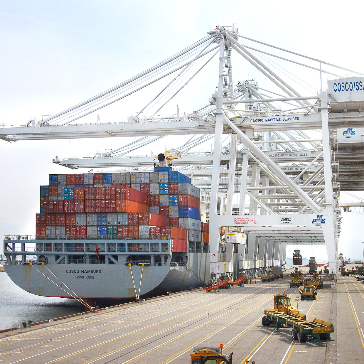 Container ship docked at a port with multiple large gantry cranes